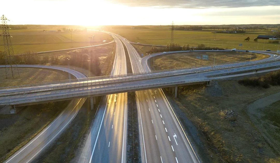 Aerial view of modern highway road intersection at dawn on rural landscape
